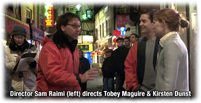 Director Sam Raimi (red jacket) directs Tobey Maguire and Kirsten Dunst